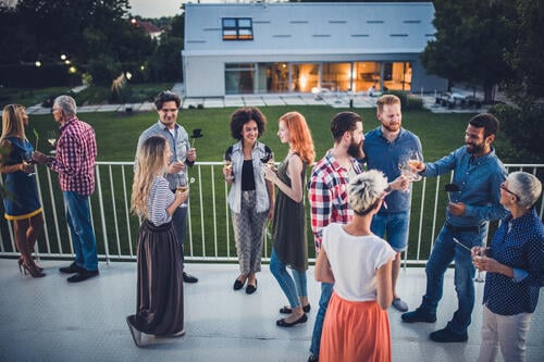 Employees sharing drinks and networking at an internal business event held outside